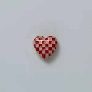 Pink and red checkerboard heart shape accessory detail shot, gold outlined stylish design.