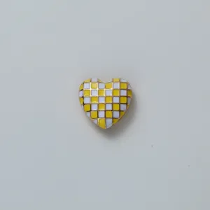Close up detail view of yellow and white checkered heart shaped fashion button accessory