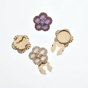 Close-up detail view of elegant floral rhinestone clothing accessories and metal snap button parts.