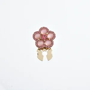 Close-up detail shot of the pink rhinestone floral brooch buckle, elegant metallic finish.