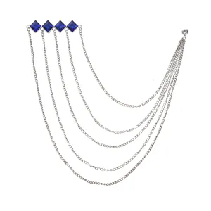 Detailed close-up of multi-layer chain brooch with blue square gems and metal tassels.