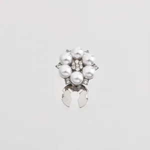 Vue de détail de pince à chemise fleur perle strass, accessoire élégant en alliage.
