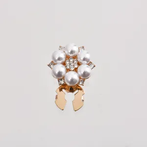 Gros plan de détail d'un bouton décoratif de chemise en alliage doré chic avec des perles.