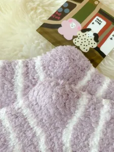 Cozy purple and white striped fuzzy sleep socks for women, soft winter warm coral fleece.