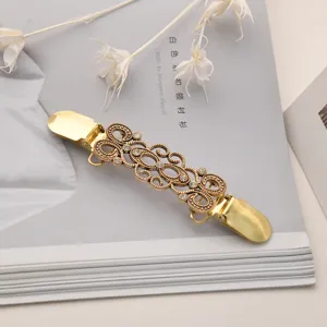 Spilla vintage in lega dorata con motivo vortice per cardigan clip dettaglio vista.