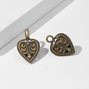 Vintage bronze tone heart shaped filigree metal clothing clip detail close up accessory view