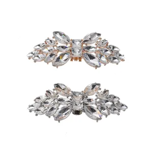 Close-up details of sparkling crystal rhinestone shoe clips, butterfly shaped metal accessories.
