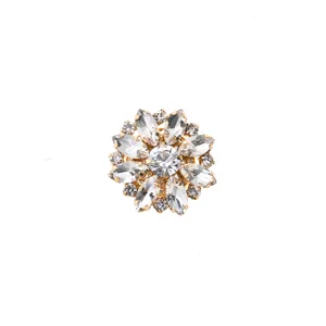 Close-up detail of luxury gold-tone crystal rhinestone flower decorative button and brooch.