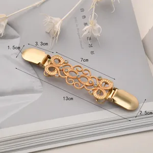 Vista di dettaglio della clip per maglione vintage dorata, design traforato con strass.