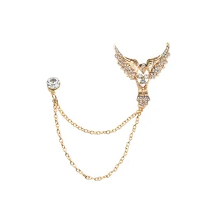 Close-up detail of the vintage gold-tone wing brooch with sparkling rhinestones and double chain.