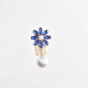 Blue rhinestone flower and white pearl pendant detail shot, exquisite gold-tone metal collar pin.