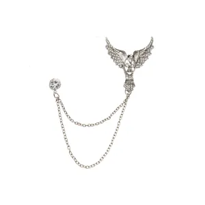Close-up detail shot of the silver wing brooch with sparkling rhinestones and delicate chains.