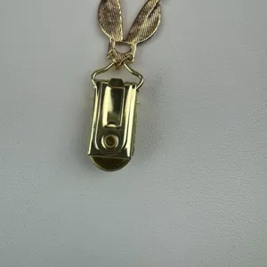 Close-up detail van de gouden metalen konijnenorentruiclip en sluiting accessoire.