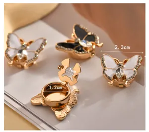Detail shot of 3d butterfly rhinestone shirt collar clip and decorative brooch accessory.