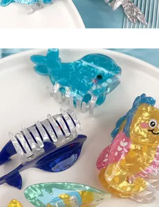 Gros plan détaillé de pinces à cheveux mignonnes animaux de l'océan avec des motifs de baleine.