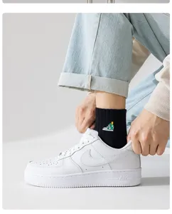 Detailed view of men's black mid-tube cotton socks with cute sneaker embroidery design.