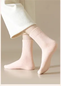 Detailed view of cozy pink ribbed knit winter socks worn on feet, soft warm texture.