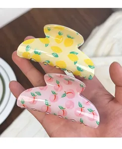 Vue détaillée de pinces à cheveux à motif de fruits avec citrons et pêches pour le style.