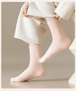 Cozy pink ribbed wool winter socks for women, thick thermal mid-tube floor socks for cold days.