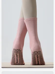 Detailansicht rosa Wadenlange Yoga Socken mit schwarzen Antirutsch Noppen Sohle.