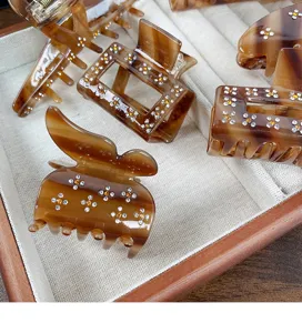 Molla per capelli in acetato marrone decorata con fiori di strass. Elegante accessorio di modo.