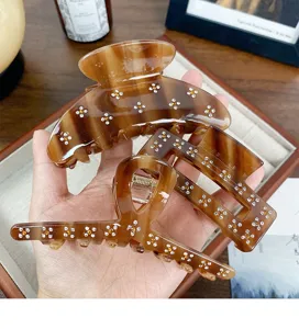 Molla per capelli marrone in acetato con dettagli floreali in strass, accessorio chic e moda.