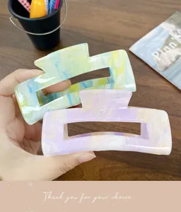 Nahaufnahme stilvoller Marmor Acryl Haarklammern in sanften Pastellfarben für Damen.