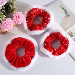 Trois chouchous de Noël rouges avec bordure en fourrure blanche et motifs argentés sur blanc.