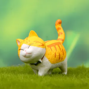 Graziosa statuetta di gatto in resina in primo piano, simpatico micino tigrato cicciottello da arredo