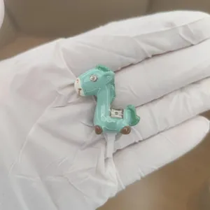 Detail view of a cute green horse 3.5mm dust plug phone accessory, resin material.