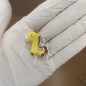 Cute yellow resin horse dust plug for 3.5mm headphone jack audio port closeup view