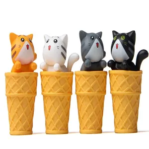 Nahaufnahme von süßen Katzenfiguren in Waffeleistüten, ideale Schreibtischdekoration.