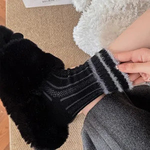 Close-up detail of cozy black and grey striped knit slouch socks with warm texture.