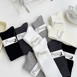 Chaussettes côtelées en coton aux coloris classiques disposées proprement sur table.