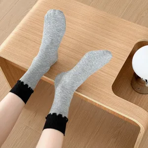 Grey mid-tube socks featuring fine vertical stripes and stylish black ruffled cuffs.