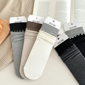 Detailed view of solid color ribbed mid-calf stack socks with cute ruffled cuffs and tags.
