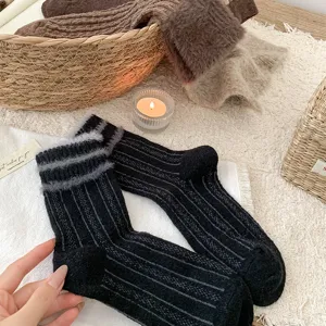 Close-up of cozy winter faux mink striped mid-tube socks in a warm lifestyle flatlay setting.