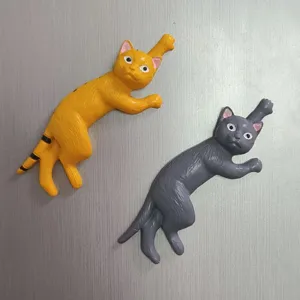 Nahaufnahme der niedlichen streckenden Katzen Kühlschrankmagnete in orange und grau.