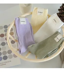 Chic pastel ribbed crew socks in assorted soft colors, featuring branded tags for casual wear.
