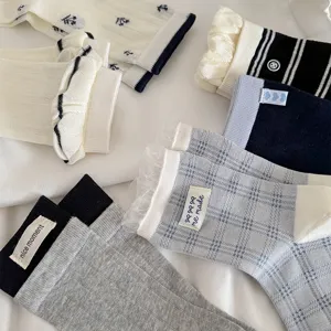 Detailed view of spring summer women socks with lace trim, stripes, and cute woven labels.