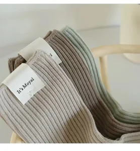 Close-up of Japanese style ribbed mid-tube slouch socks showing detailed knit and brand label.