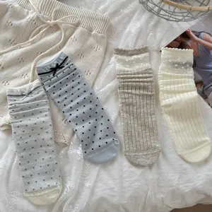 Detailed view of sweet Japanese style hollow bow and polka dot mesh stacked socks for women.