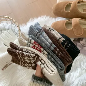 Chaussettes d'hiver douillettes en laine pour femme avec motif flocon de neige traditionnel.