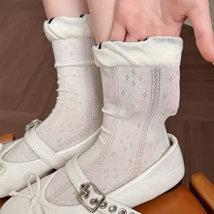 Close-up detail view of women's white mesh ruffled short socks worn with classic shoes.