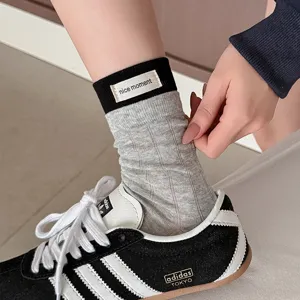 Cotton ribbed socks detail view, featuring contrast color top and cute fabric label design.