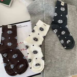 Cozy winter mid-calf cotton socks featuring snowflake and polka dot patterns with woven label.