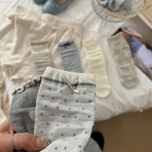 Close-up detail view of cute sheer polka dot socks with delicate bows for women spring.