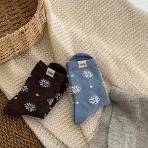 Cozy winter knit mid-tube socks with snowflake patterns and fabric tags, soft cotton warm.