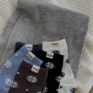 Detailed view of cozy winter cotton mid-tube socks with cute snowflake and dot patterns.