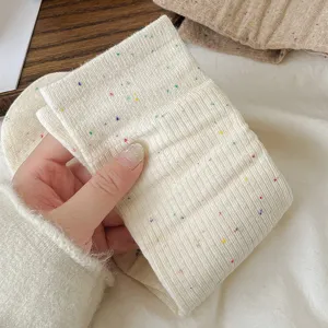 Primo piano di calzini da donna a coste verticali con dettagli in filato colorato.
